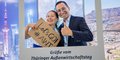 Zwei Personen sind lachend hinter einem weißem Bildrahmen mit der Aufschrift: Grüße vom Thüringer Außenwirtschaftstag