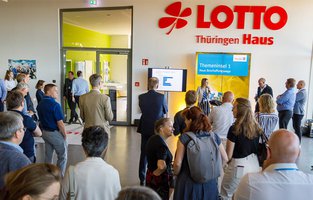 Eine Frau hält eine Präsentation vor ungefähr 30 Zuhörern.