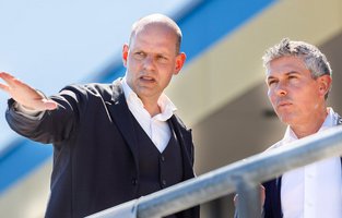 Eine Person zeigt in die Ferne und erklärt einer anderen Person etwas.