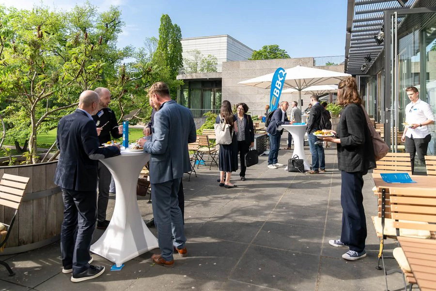 InnoCON Bildergalerie Gruppe von Leuten versammelt sich um Tische bei einem Outdoor-Event.
