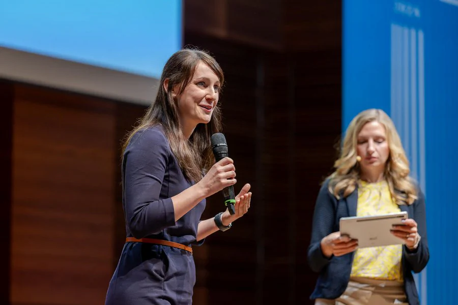 InnoCON Bildergalerie Foto: Zwei Frauen halten eine Rede auf der Bühne
