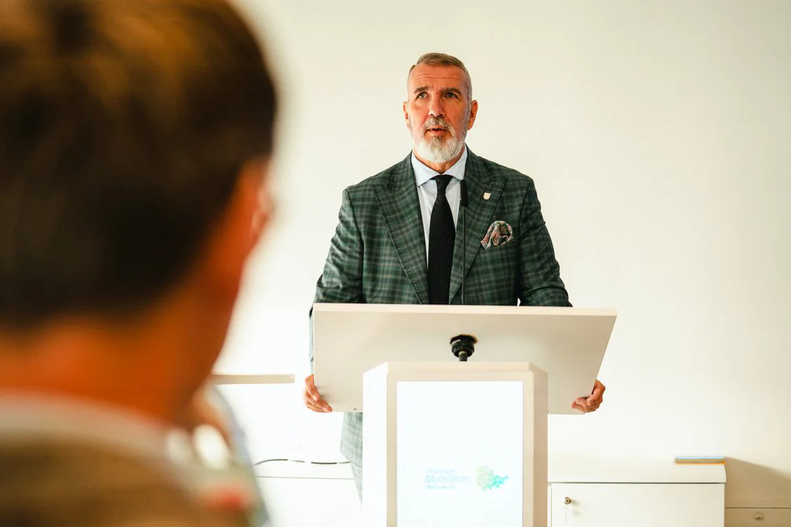 Copyright: TMDI / B. Schmidt Steffen Schütz speaks at a lectern of the Thuringian Mobility Network in front of participants of the Thuringian Mobility Conference 2026.