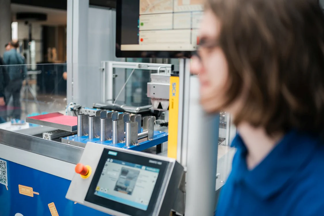 Automatisierte Produktions- oder Prüfanlage mit Bedienpanel und Metallbauteilen auf dem Maschinenbautag 2026.