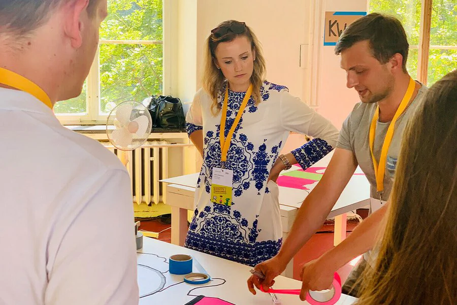 Mehrere Menschen versammeln sich um einen Tisch und führen ein lebhaftes Gespräch.