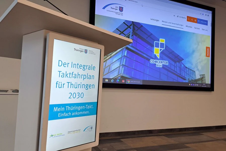 Rednerpult vor einer Präsentationsleinwand und Inhalten zum ITF Forum