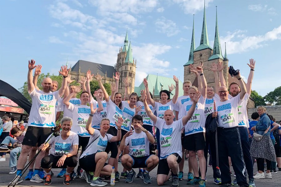 Eine Gruppe von Sportlern posieren nach einem Rennen für ein Foto vor dem Erfurter Domplatz