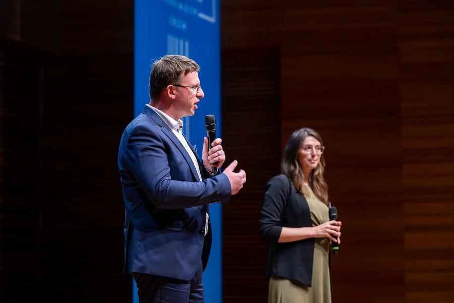 InnoCON Bildergalerie Foto: Robert Weigelt (LEG) und ein weiterer Gast halten eine Rede auf der Bühne
