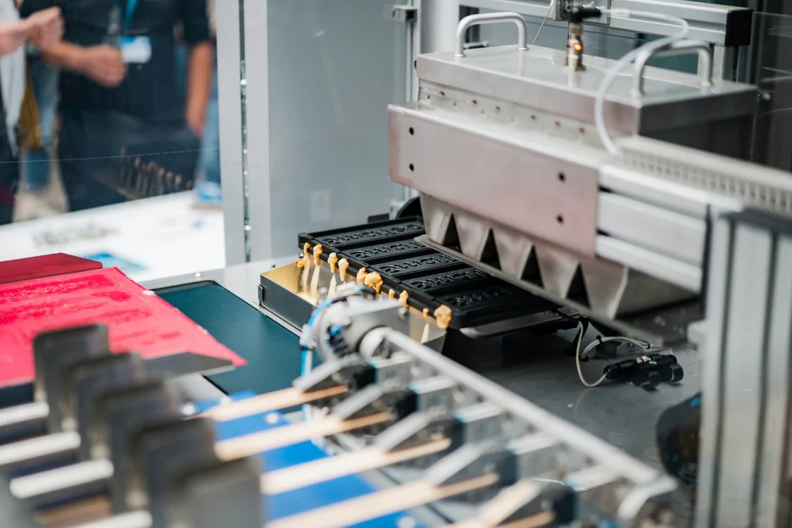 Automatisierte Fertigungsanlage verarbeitet Bauteile in einem Ausstellungsbereich des Maschinenbautags 2026.