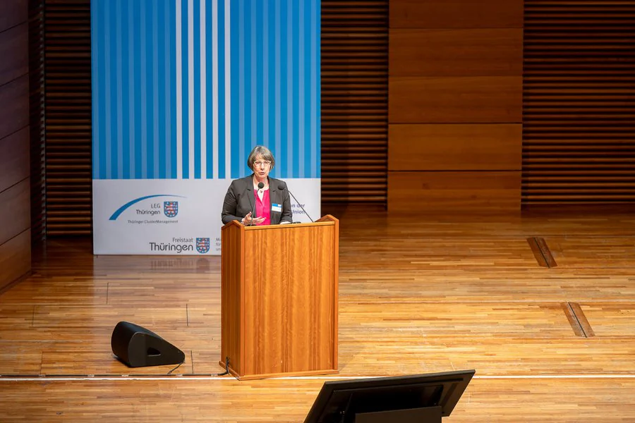 InnoCON Bildergalerie Foto: Frau hält Rede vor einem Publikum am Rednerpult.