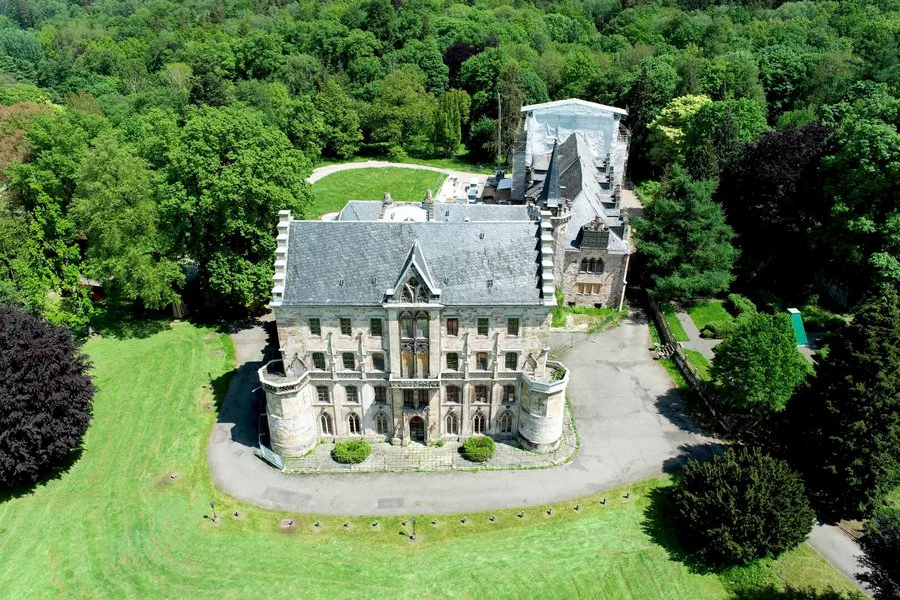 Luftaufnahme Schloss Reinhardsbrunn Luftaufnahme eines Schlosses, umgeben von üppigen Bäumen, die eine malerische Landschaft bilden.