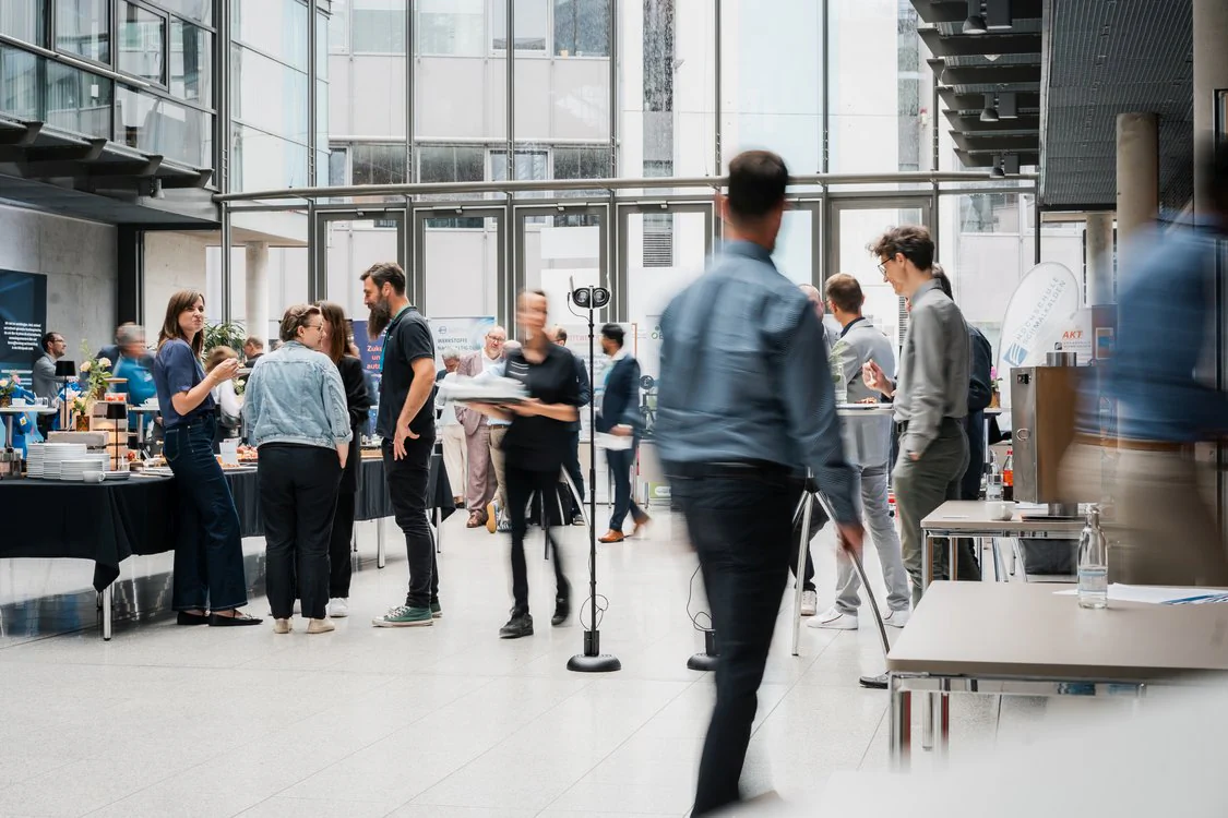 Teilnehmende des Maschinenbautags 2026 nutzen eine Veranstaltungspause für Gespräche und Networking im Ausstellungsbereich.