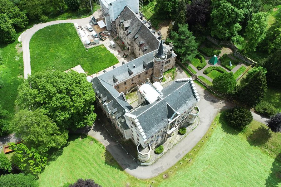 Luftaufnahme Schloss Reinhardsbrunn Luftaufnahme eines Schlosses mit einem Turm und einem Innenhof, umgeben von grüner Landschaft