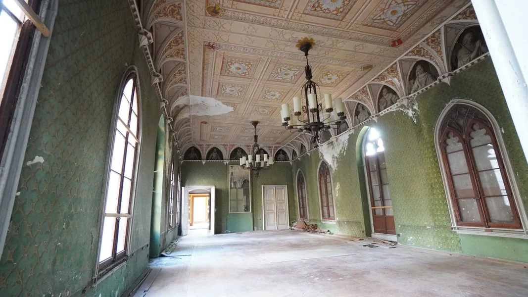 Innenraum Schloss Reinhardsbrunn Das Innere eines verlassenen Schlosses mit grünen Wänden und aufwändiger Stuckdecken und zwei Kerzenkronleuchtern