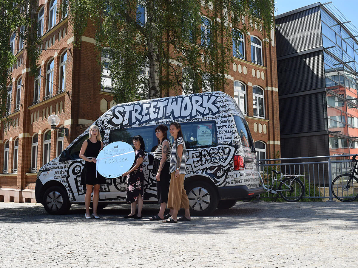 Soziales Engagement: Spendenübergabe u. a. an die Streetworker Erfurt Bildbeschreibung / description: Übergabe vor einem schwarz-weiß beklebtem Kleinbus beim LEG Gebäude