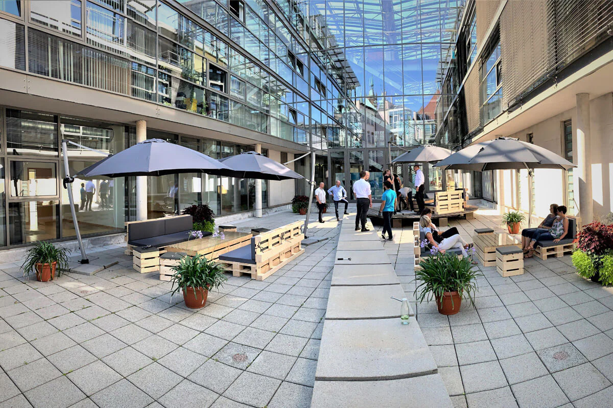 Bildbeschreibung / description: Innenhof des LEG Gebäudes mit Schirmen und Sitzgelegenheiten